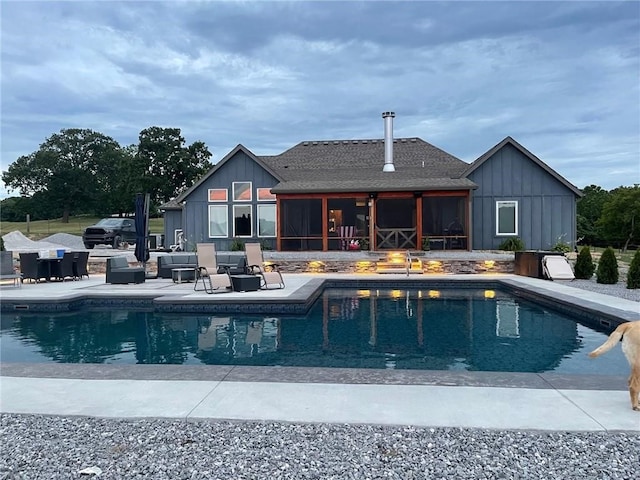 outdoor pool with a patio and a sunroom