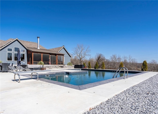 outdoor pool with a patio area and a sunroom