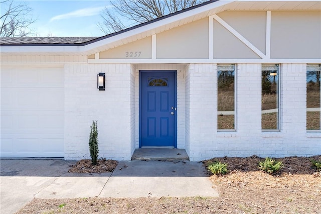 property entrance featuring brick siding and a garage