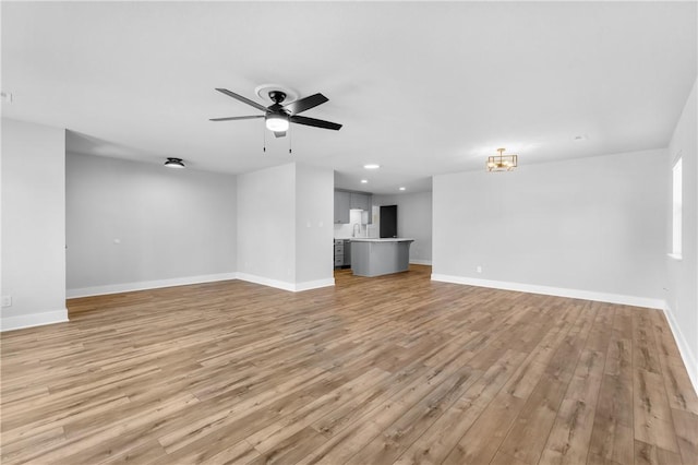 unfurnished living room featuring light wood finished floors, recessed lighting, a ceiling fan, and baseboards