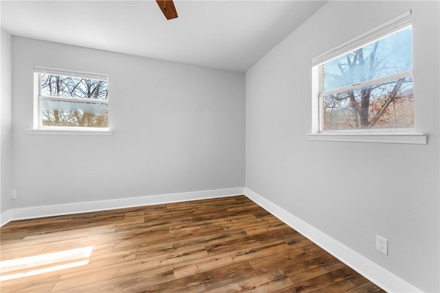 unfurnished room with hardwood / wood-style flooring, plenty of natural light, a ceiling fan, and baseboards