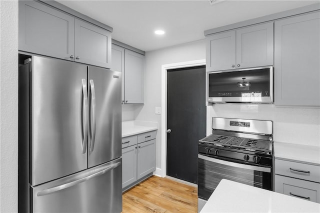 kitchen with gray cabinets, stainless steel appliances, and light countertops