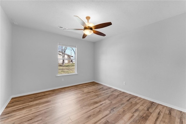 unfurnished room featuring visible vents, baseboards, ceiling fan, and wood finished floors