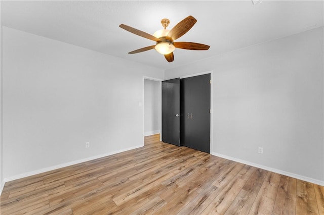 unfurnished bedroom with a closet, baseboards, light wood-style floors, and ceiling fan