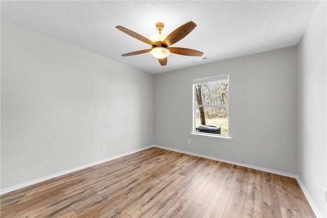 unfurnished room with visible vents, baseboards, a ceiling fan, and wood finished floors