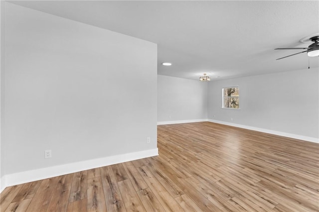 unfurnished room with ceiling fan, baseboards, and wood finished floors