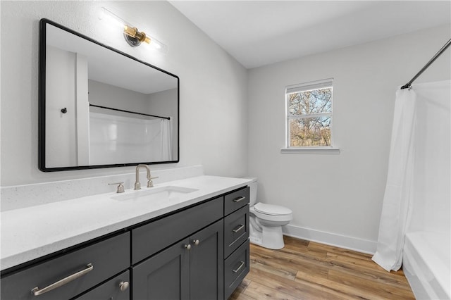 full bathroom featuring vanity, toilet, wood finished floors, and baseboards