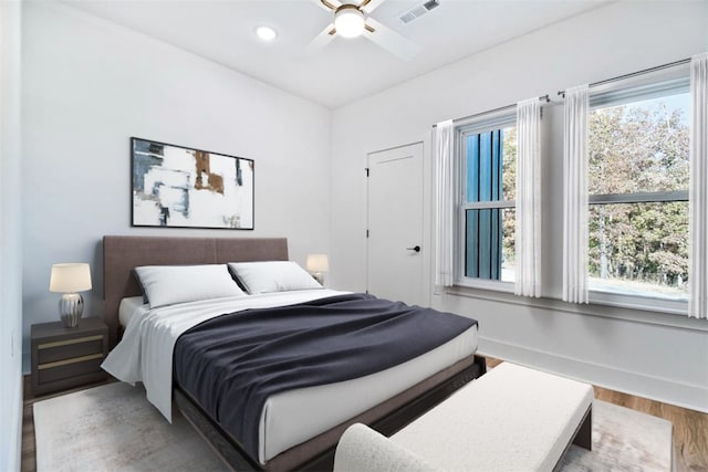 bedroom with a ceiling fan, wood finished floors, visible vents, baseboards, and recessed lighting