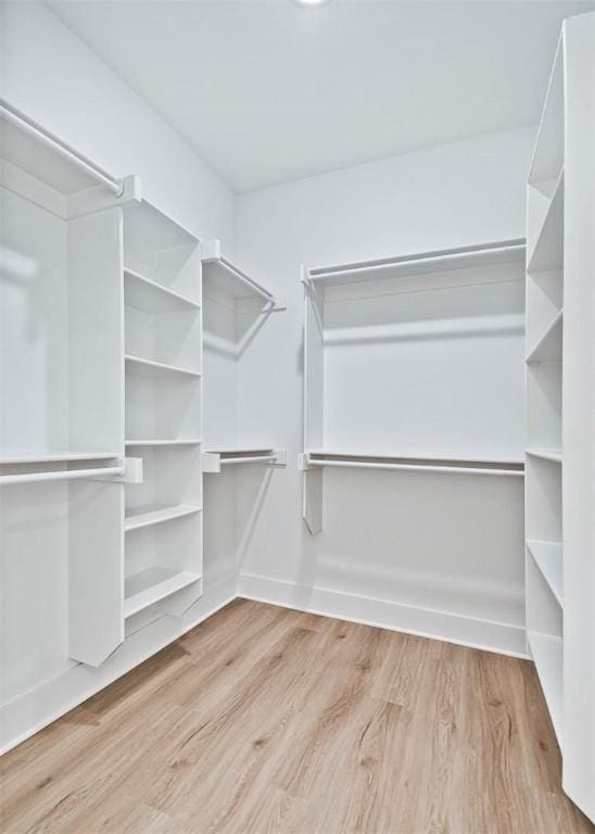 walk in closet with wood finished floors