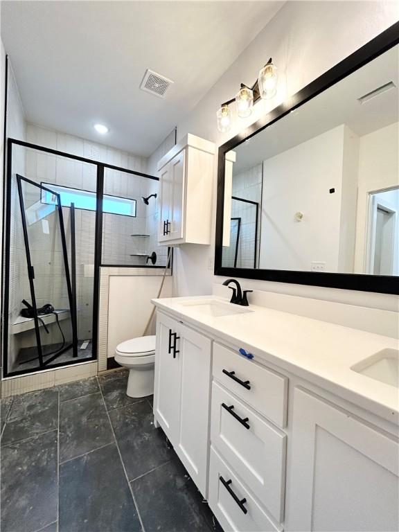 full bath featuring a shower stall, toilet, visible vents, and a sink