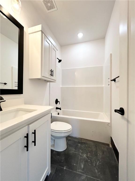 full bathroom with visible vents, toilet, vanity, and washtub / shower combination