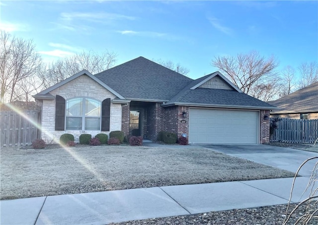 single story home featuring a shingled roof, fence, driveway, stone siding, and an attached garage