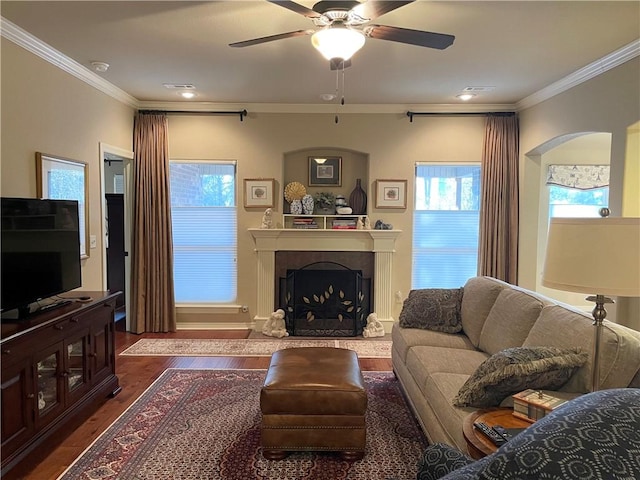 living room featuring arched walkways, crown molding, ceiling fan, and dark wood-style flooring