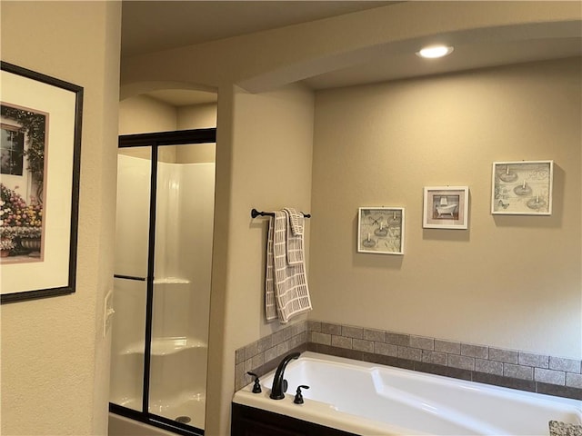 bathroom with a shower with shower door and a garden tub