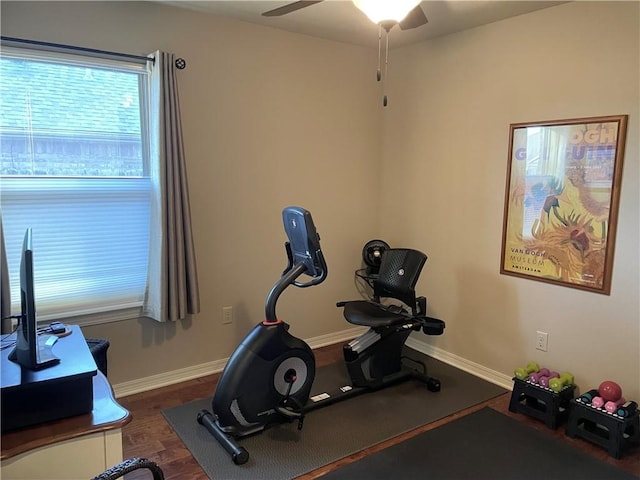 workout room featuring baseboards, a ceiling fan, and wood finished floors