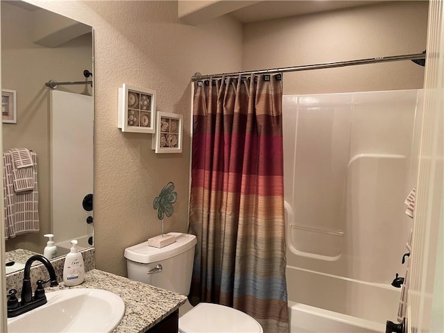 full bath featuring vanity, toilet, a textured wall, and shower / bath combo