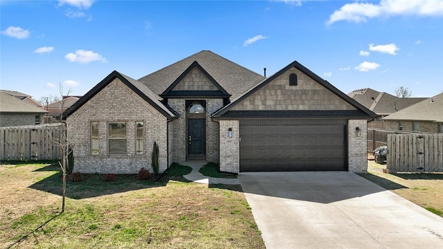 view of front of home with fence, concrete driveway, brick siding, and a garage