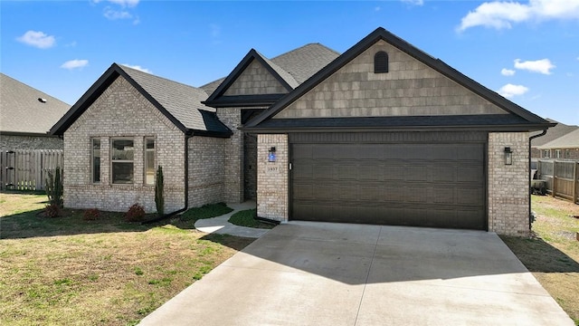 view of front of property featuring concrete driveway, a front yard, an attached garage, fence, and brick siding