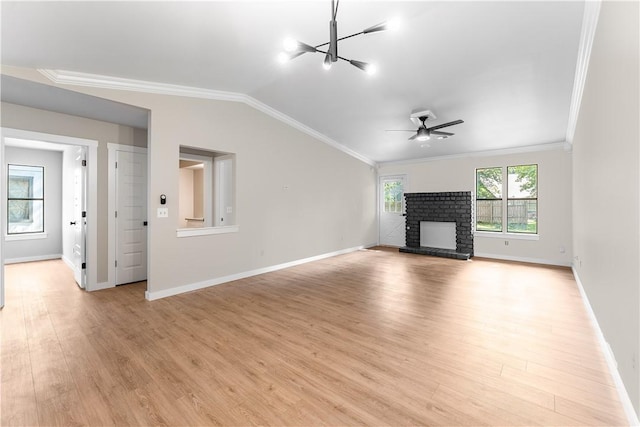 unfurnished living room with a brick fireplace, crown molding, baseboards, lofted ceiling, and light wood-style flooring