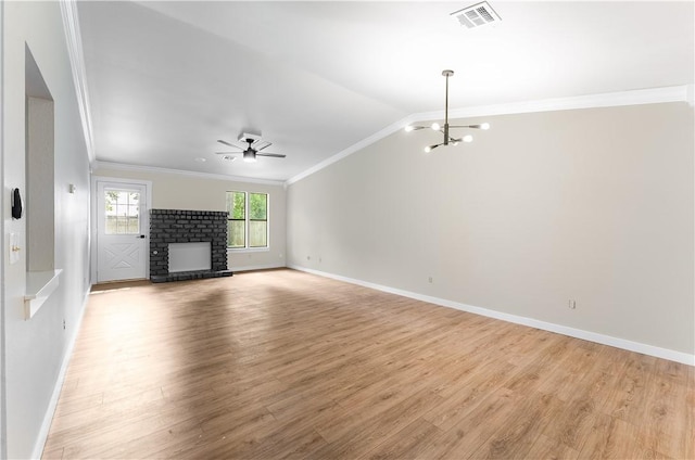 unfurnished living room with visible vents, ornamental molding, light wood-style flooring, ceiling fan with notable chandelier, and a fireplace