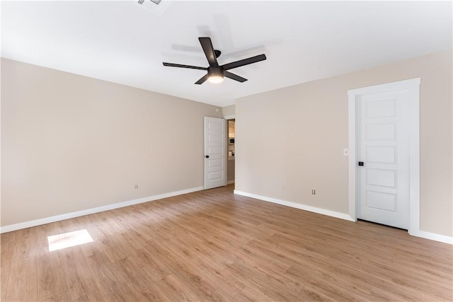 spare room with light wood finished floors, visible vents, ceiling fan, and baseboards