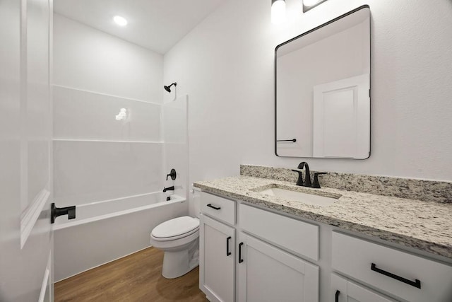 bathroom with vanity,  shower combination, toilet, and wood finished floors