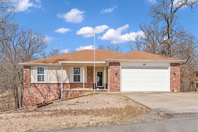 single story home with concrete driveway, an attached garage, and brick siding