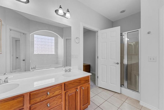 full bathroom with tile patterned flooring, a stall shower, and a sink