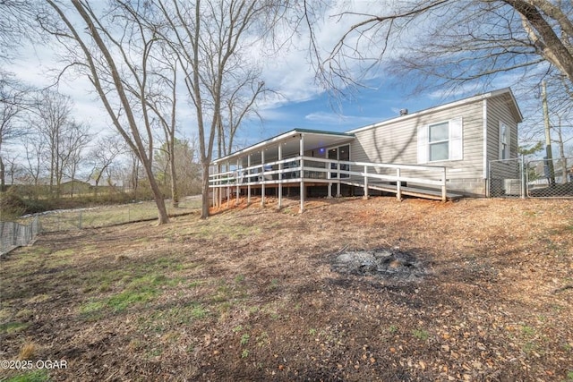 back of property featuring a wooden deck and fence