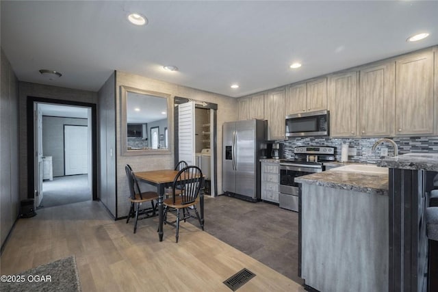 kitchen featuring a sink, stainless steel appliances, tasteful backsplash, and recessed lighting