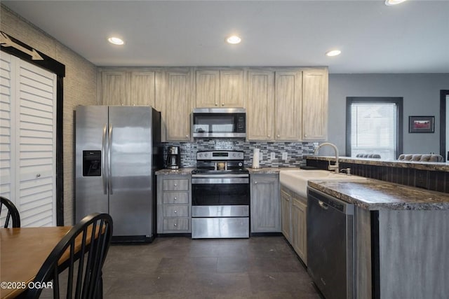 kitchen featuring decorative backsplash, recessed lighting, appliances with stainless steel finishes, a peninsula, and a sink