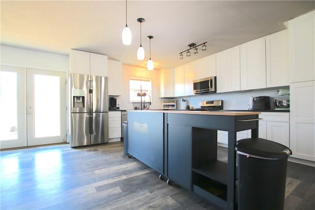 kitchen with pendant lighting, dark wood finished floors, white cabinetry, stainless steel appliances, and french doors