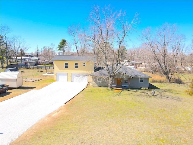 view of front of property featuring a front lawn, concrete driveway, and a garage