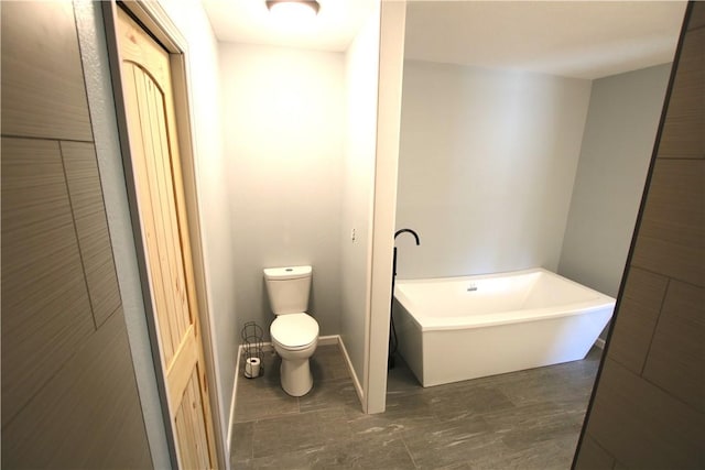 full bathroom with a freestanding tub and toilet