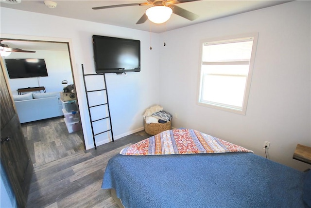 bedroom with ceiling fan, baseboards, and wood finished floors