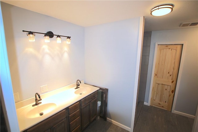 full bath featuring wood finished floors, visible vents, baseboards, and a sink