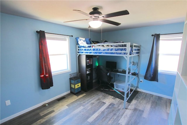 bedroom with visible vents, ceiling fan, baseboards, and wood finished floors