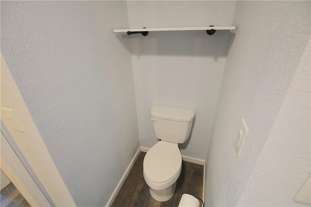 bathroom with toilet, wood finished floors, and baseboards