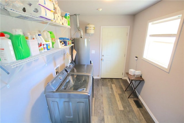 laundry room with wood finished floors, baseboards, laundry area, gas water heater, and washing machine and dryer