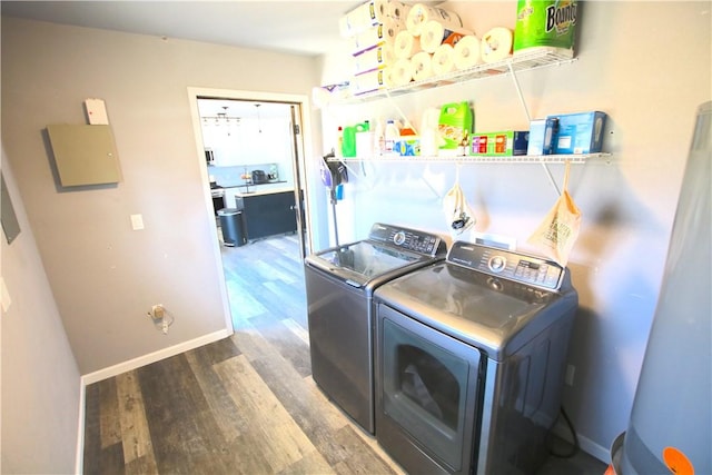 laundry area with washer and dryer, baseboards, and wood finished floors