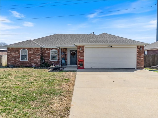 single story home with a front lawn, an attached garage, fence, and brick siding