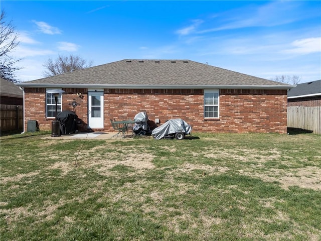 back of property featuring a yard, a patio, brick siding, and fence