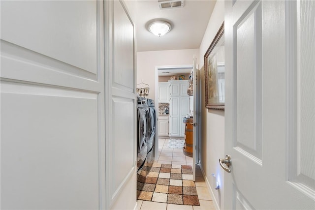 laundry room featuring light tile patterned floors, visible vents, washer and dryer, and cabinet space