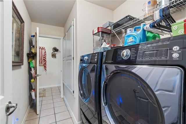 laundry room with tile patterned floors, baseboards, laundry area, and washing machine and clothes dryer