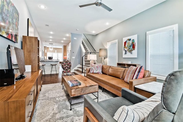 living room with light wood finished floors, stairway, recessed lighting, and ceiling fan