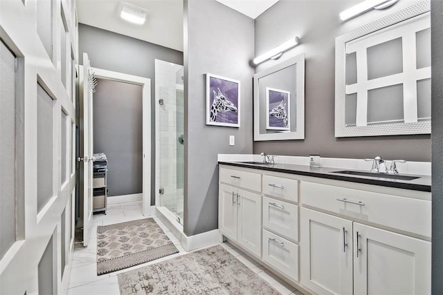 bathroom with a sink, marble finish floor, a stall shower, and double vanity