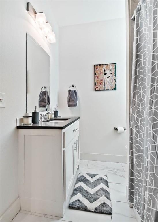 full bath featuring baseboards, marble finish floor, vanity, and a shower with curtain