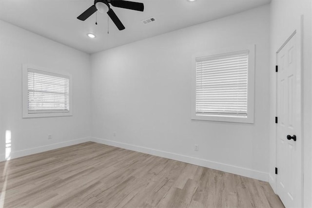 spare room featuring ceiling fan, baseboards, visible vents, and light wood-type flooring