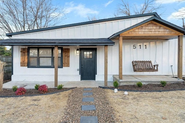 view of front of house featuring a porch, board and batten siding, and a shingled roof