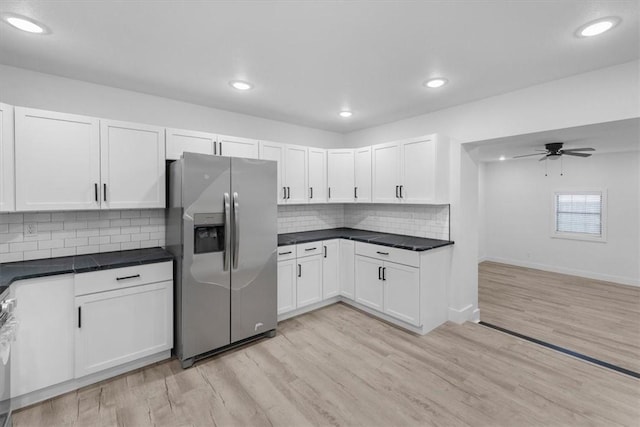 kitchen featuring dark countertops, stainless steel fridge, light wood-style flooring, and a ceiling fan